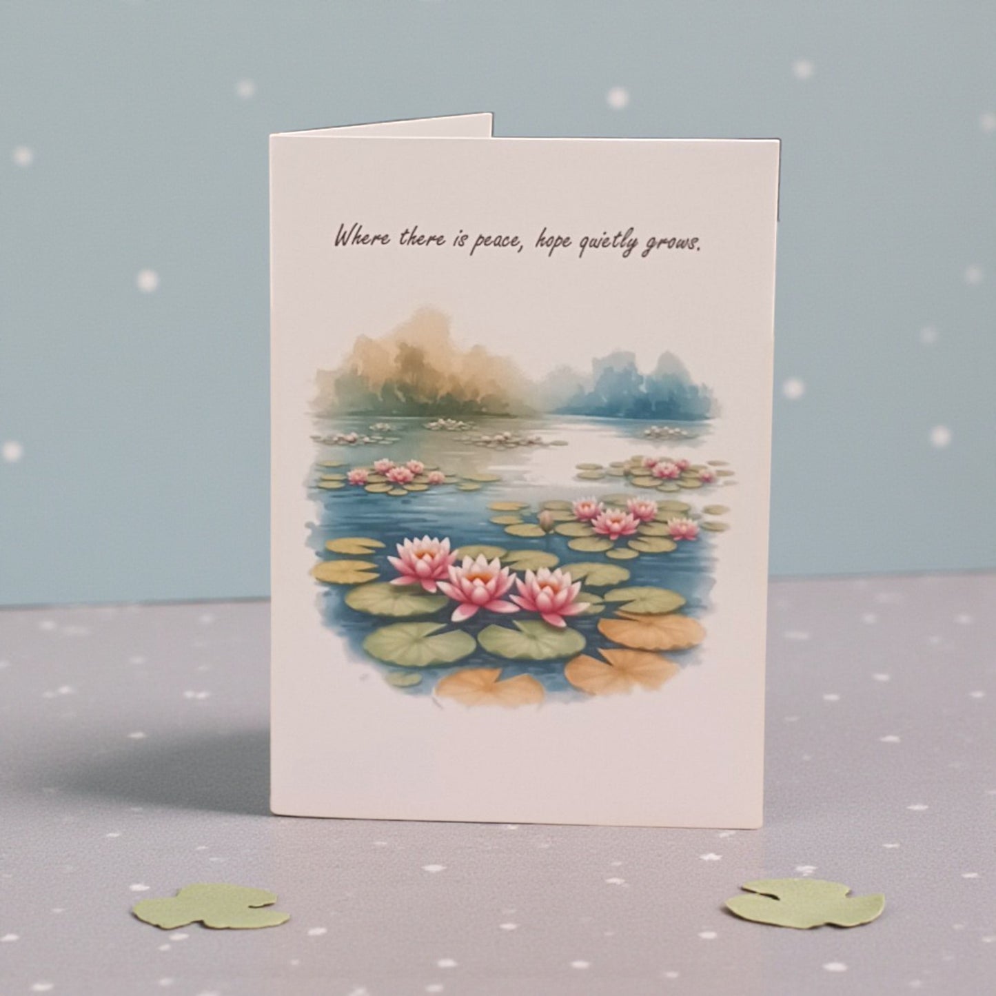 Greeting card with waterlily design and text on a gray surface