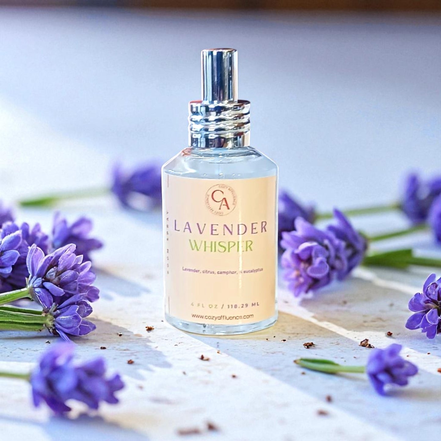 Bottle of 'Lavender Whisper' with lavender flowers on a wooden surface