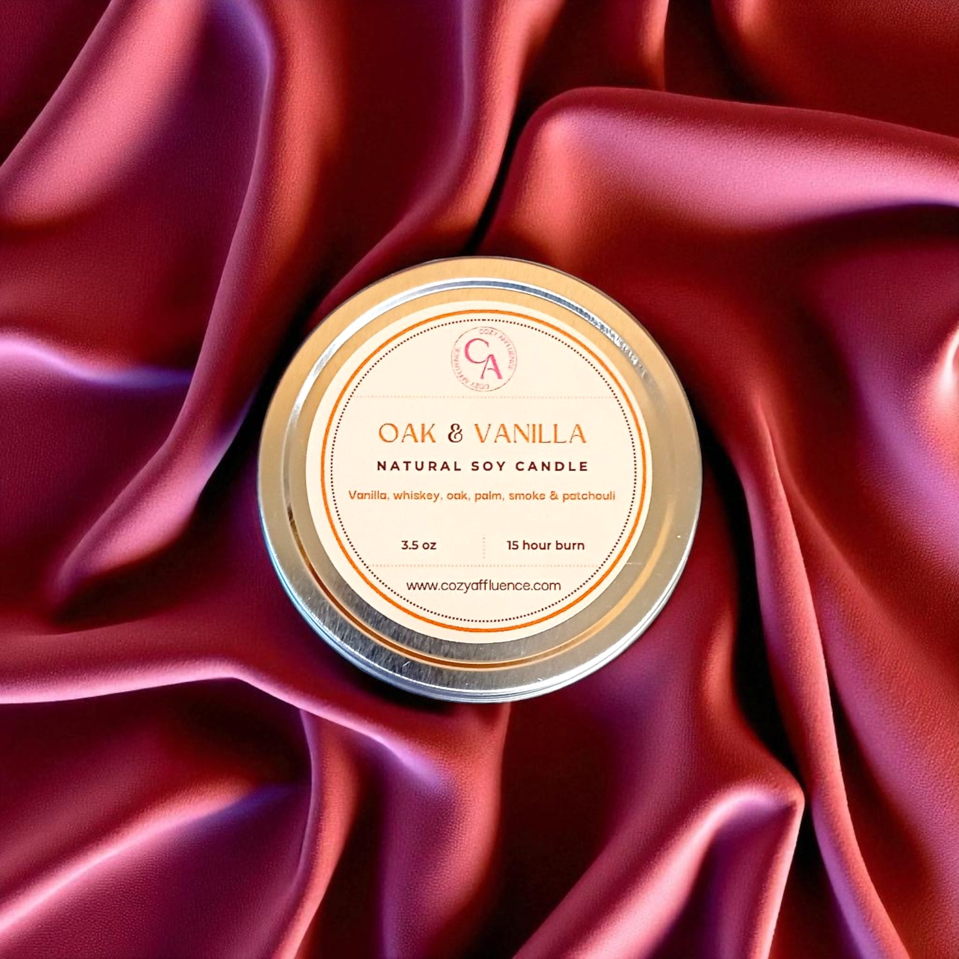 Natural soy candle labeled 'Oak & Vanilla' on a red satin background.