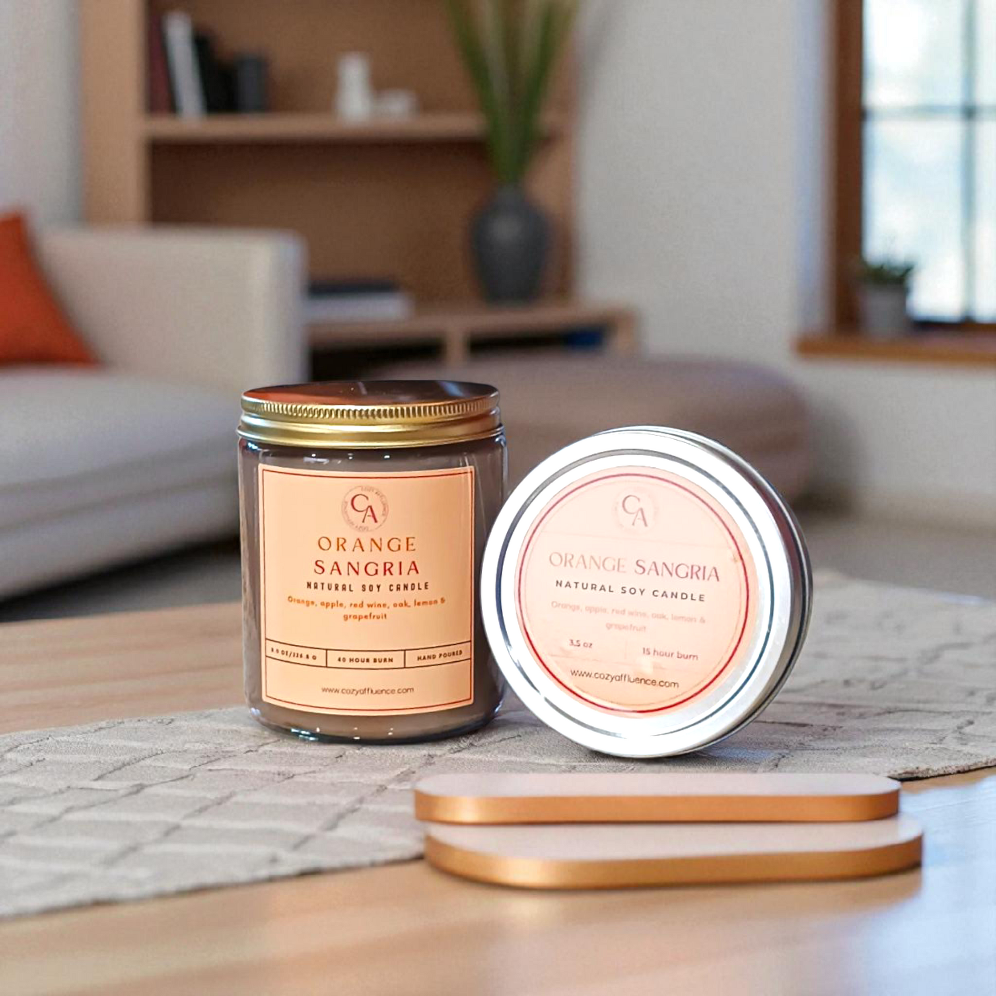 Orange Sangria 8 oz candle and 3.5 oz tin on a table in a living room setting.