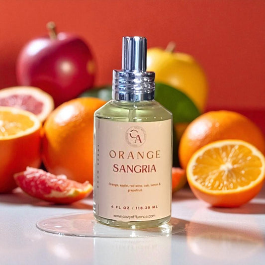 Bottle of Orange Sangria room spray with fruits in the background