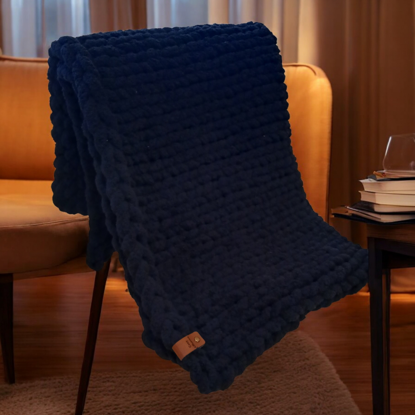 Black chunky knit blanket over a chair in a cozy living room.