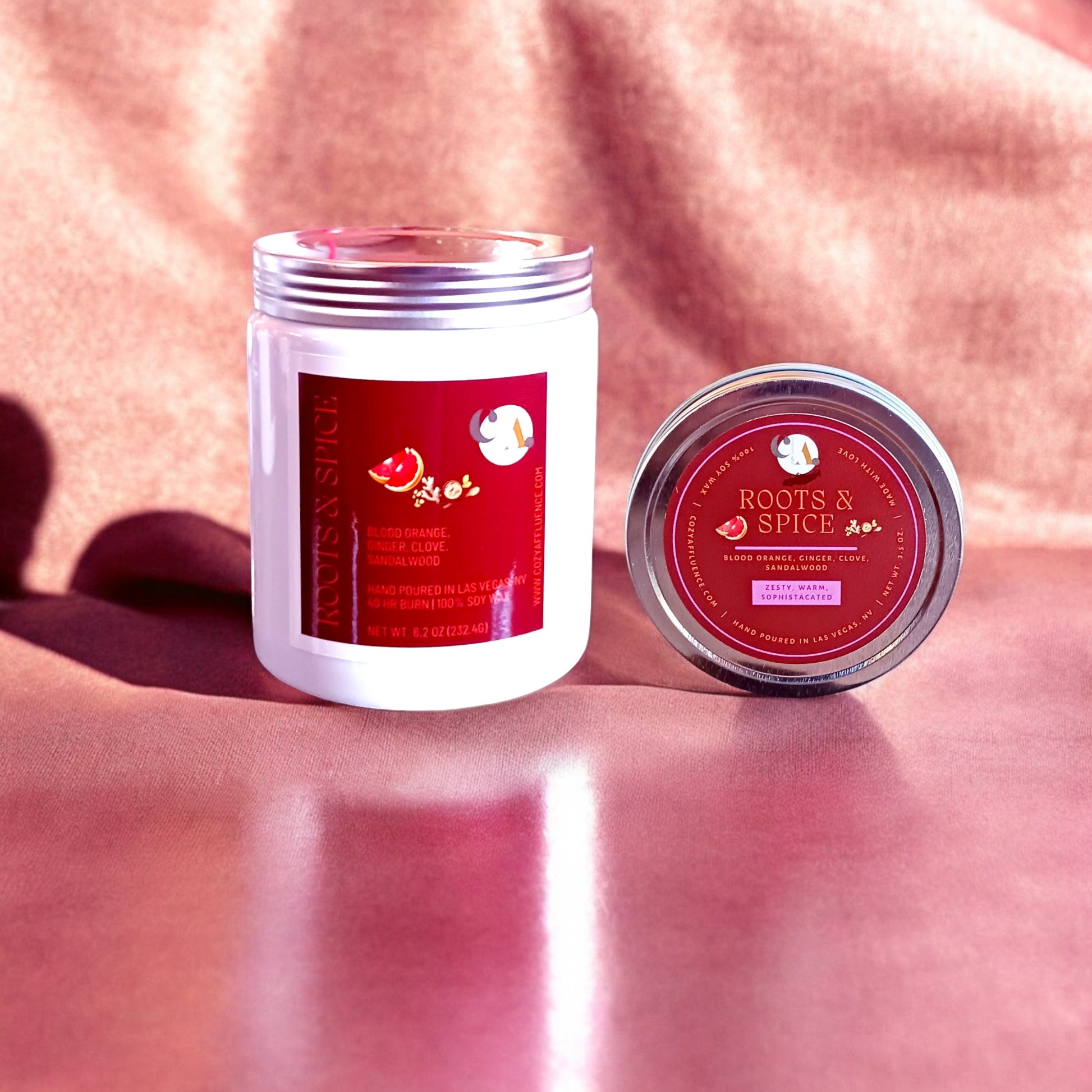 Roots & Spice 8oz & 3.5oz candle and tin combo on a soft red background.