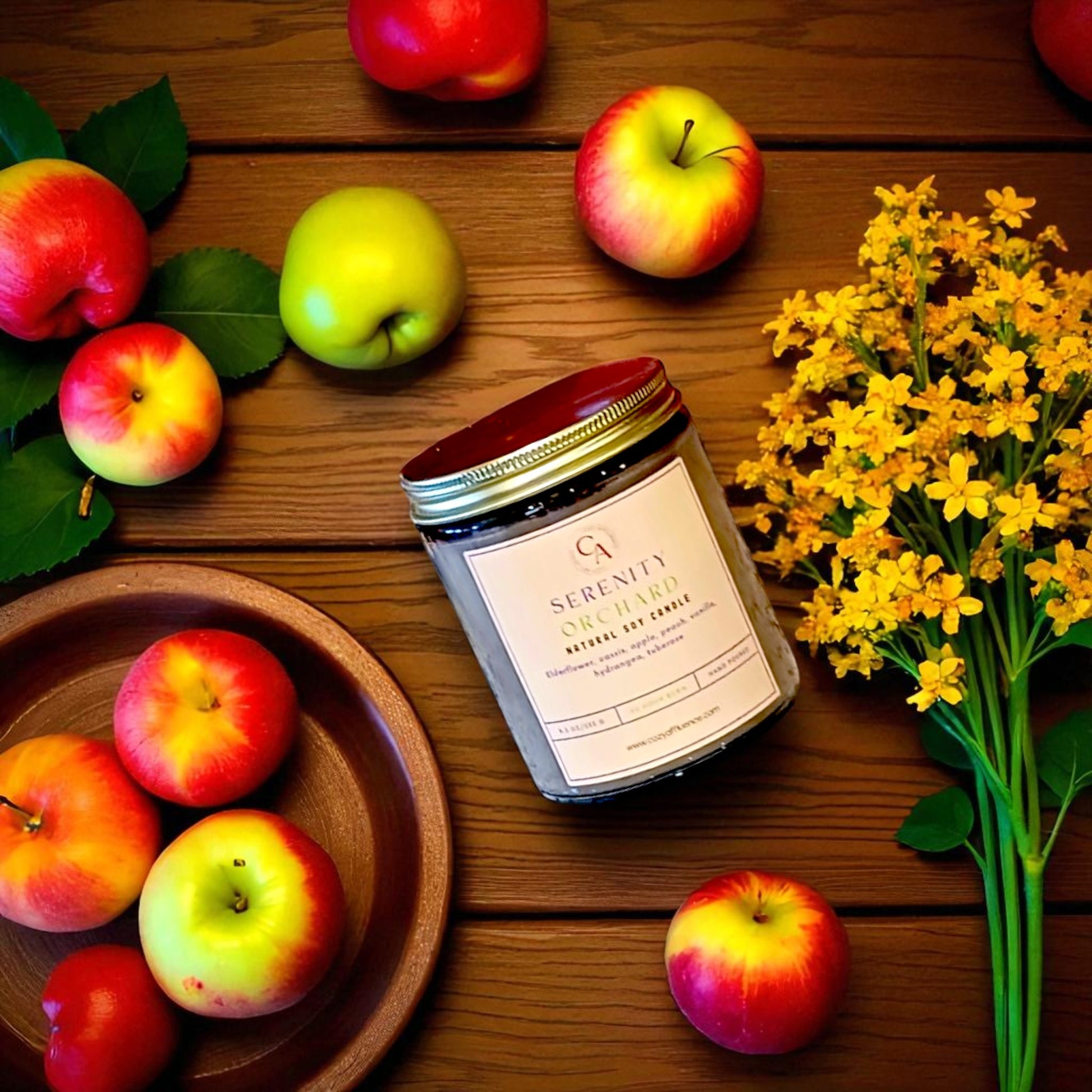 Candle jar labeled 'Serenity' with apples and flowers on a wooden surface.