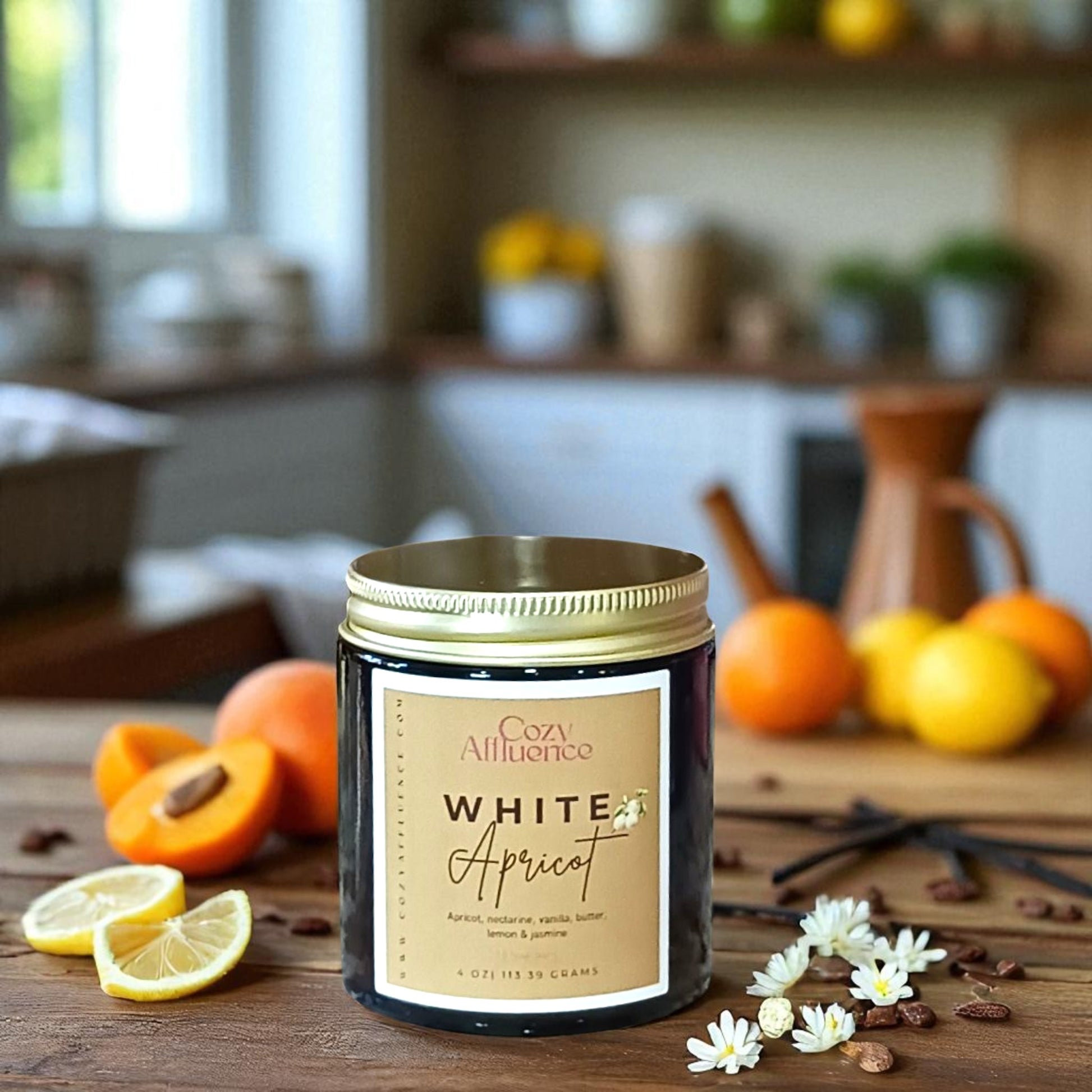 Candle labeled 'White Apricot' on a wooden table with fruits and flowers in a kitchen setting