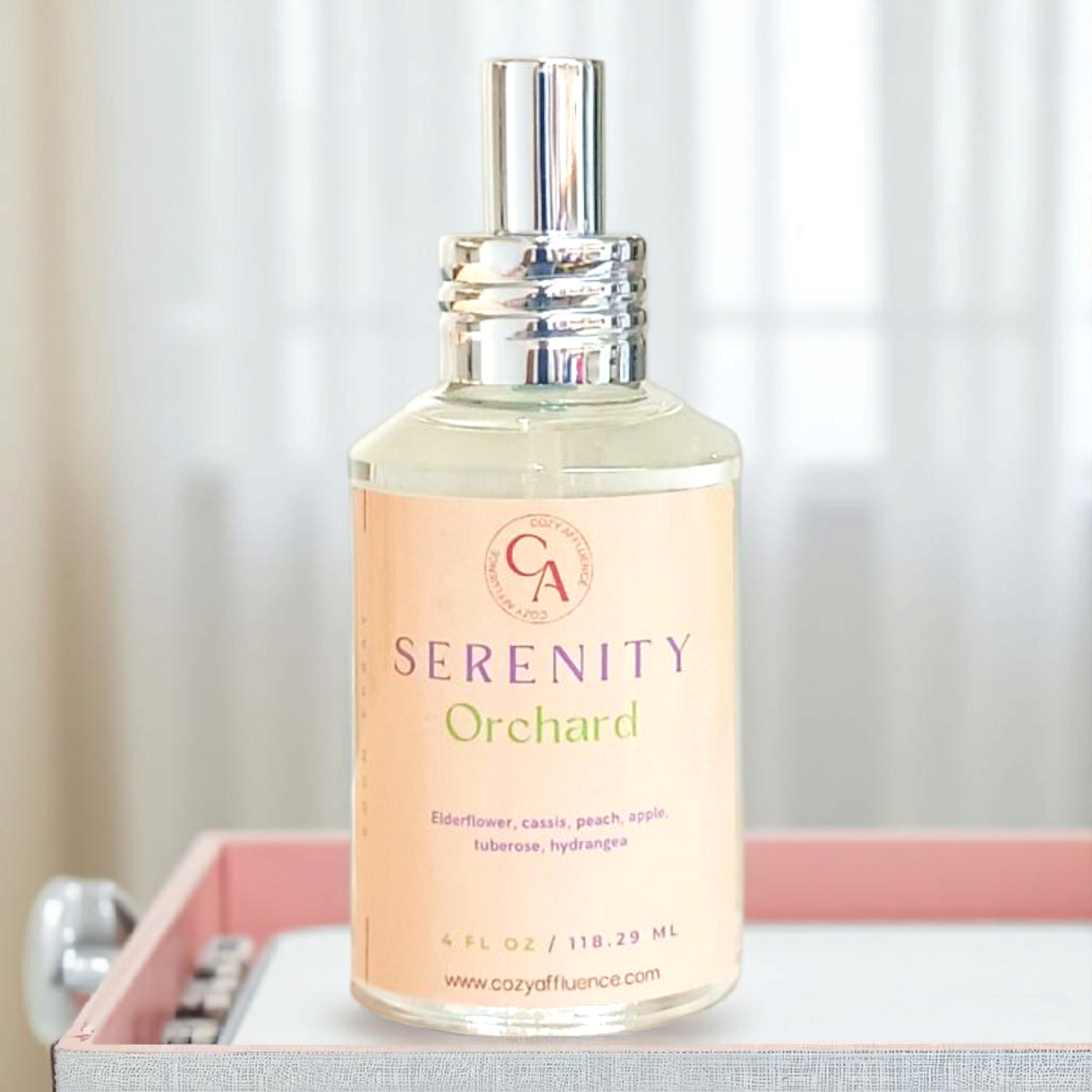 Bottle of 'Serenity Orchard' room spray on a surface with a neutral background.
