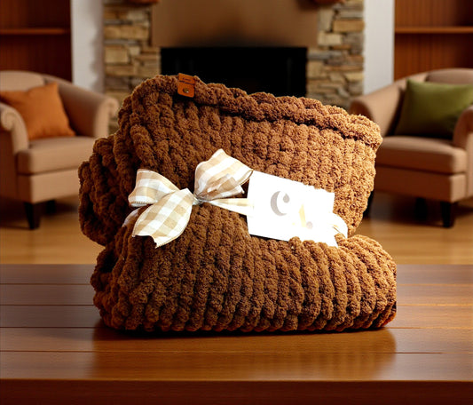 Brown textured blanket with a bow on a wooden surface in a cozy living room setting.
