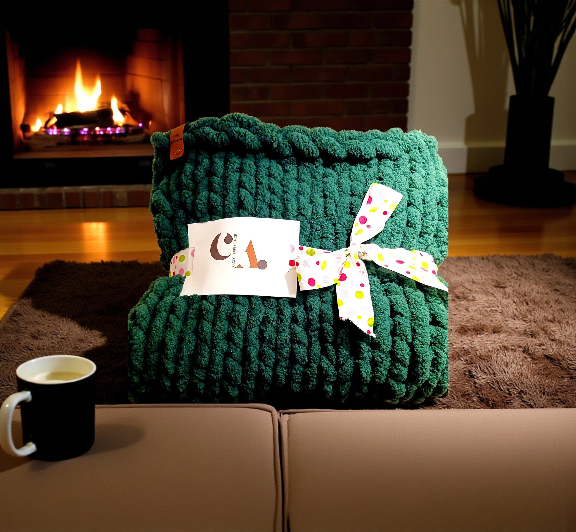 Green knitted blanket with a decorative bow on a couch in front of a fireplace.