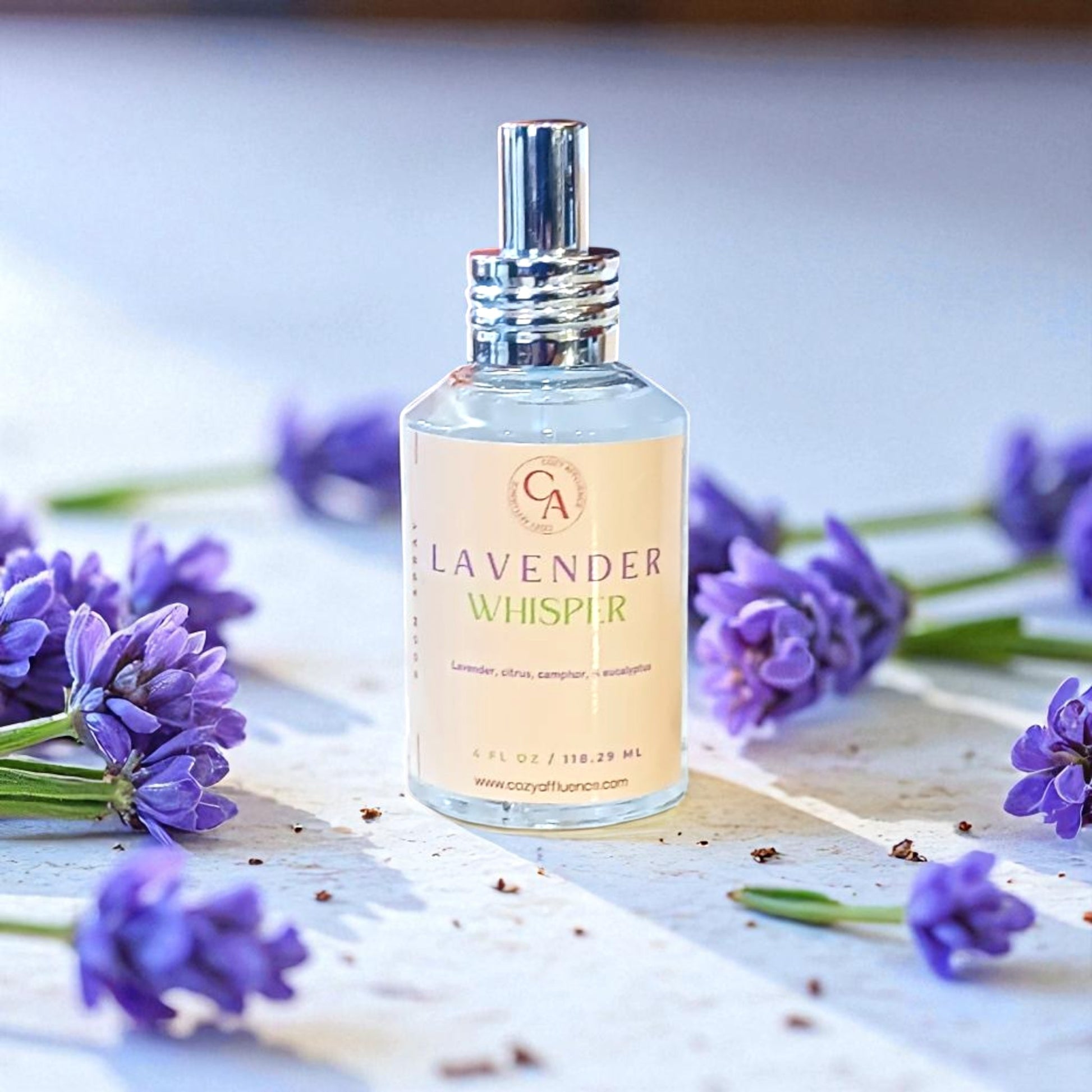 Bottle of 'Lavender Whisper' with lavender flowers on a wooden surface